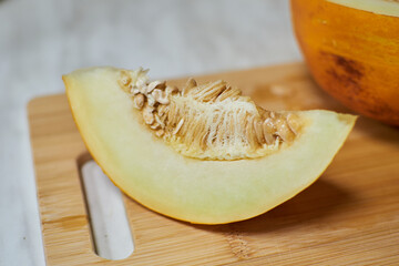 Hand-Cutting Ripe Melon on Wooden Cutting Board