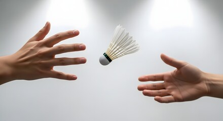 Hands reaching for a badminton shuttlecock in midair