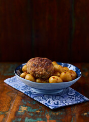 Fried meatballs with potatoes on a rustic background. Selective and soft focus.