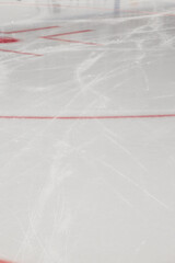 Ice scratched by skates on a hockey rink - closeup of the red markings