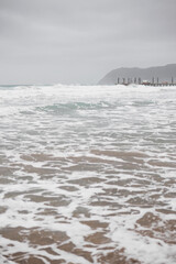 The stormy, foamy Mediterranean Sea on the coast of Italy - a beach in the town of Alasio, Liguria