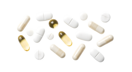 Assortment of various white and yellow oval and capsule shaped pills scattered on black background