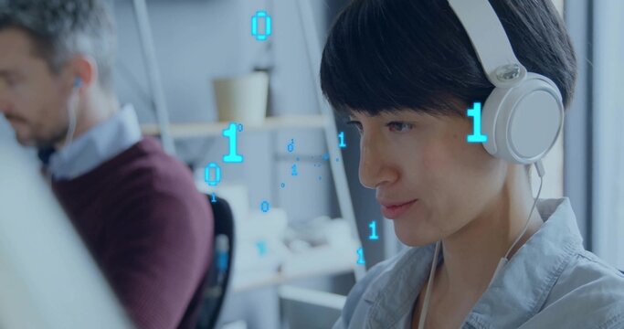 Working woman engineer wearing white over-ear headphones and light collared shirt at desk with bin - Powered by Adobe