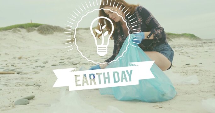 Kneeling woman collecting trash on beach, blue-gloved, plaid, holding blue bag, Earth Day overlay