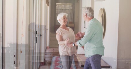 Holding hands couple, woman wearing pink top, man wearing green shirt in hallway with runner rug