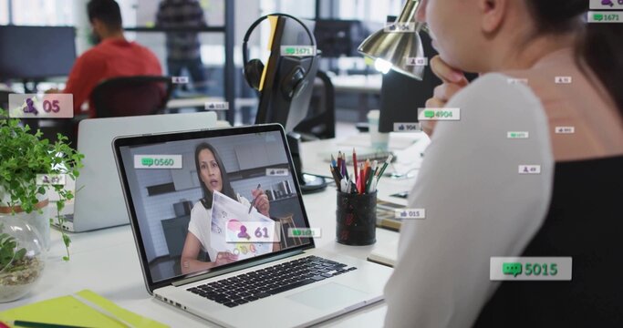 Watching woman wearing light top, viewing online call at open office on silver laptop, copy space - Powered by Adobe