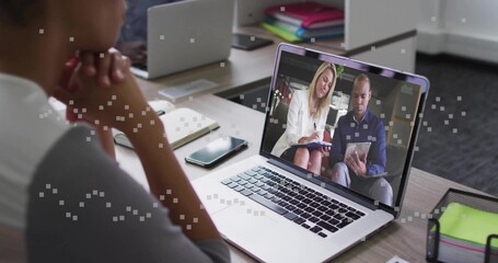 Watching woman resting chin at shared desk, viewing laptop call showing white blazer and blue shirt