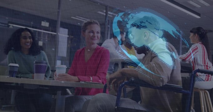 Chatting office team holding takeaway cups around long table in lounge, showing wheelchair AR globe