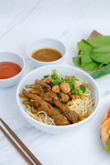 Close up mie ayam or traditinal Indonesian chicken noodle with chicken feet topping served on the table