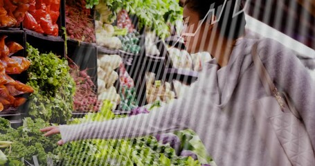 Woman spotting leafy greens, reaching and inspecting in grocery, diagonal stripes overlaying frame - Powered by Adobe