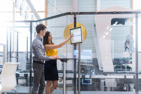 Employees planning production with industrial robots in factory