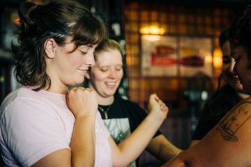 Women friends enjoying candid moment together in bar
