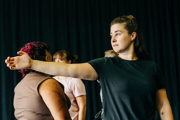 Women rehearsing dance movement together in studio