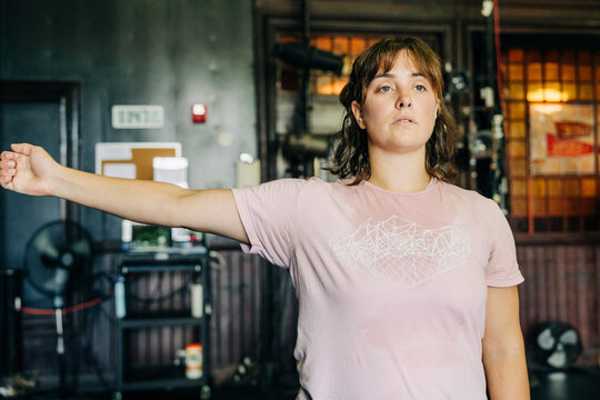 Person extends arm outward while rehearsing indoors with focus