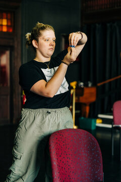 Woman concentrating, holding small blue object in hands