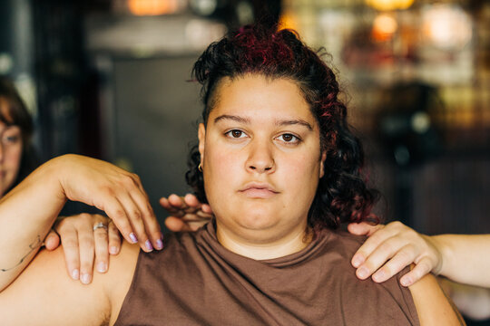 Person with multiple hands touching shoulders feeling pressure