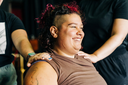 Woman smiling and laughing supported by friends