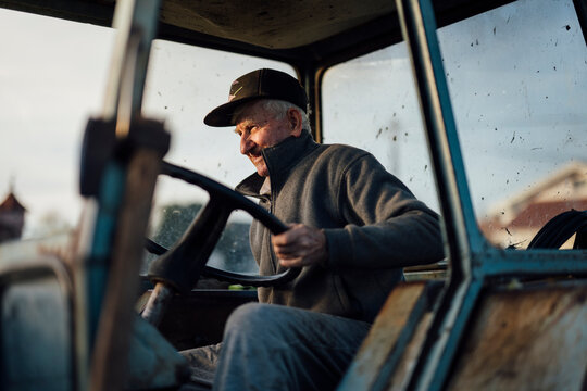 Elderly man drives a vintage tractor