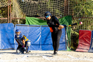 Kids playing baseball, batter hitting ball with catcher