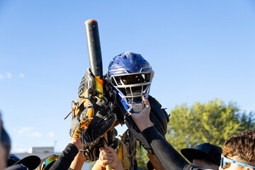 Team players raising baseball equipment celebrating victory