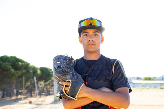 Young male baseball player posing confidently on field - Powered by Adobe