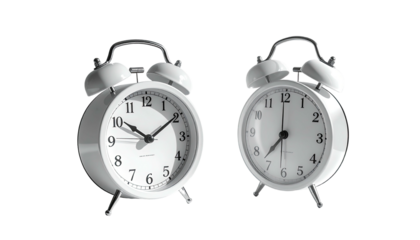 Two white, shiny, metal alarm clocks on a dark background