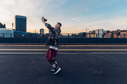 Hipster man vlogging through digital camera on road