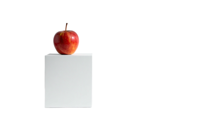 Red apple sits on white square against a stark black background