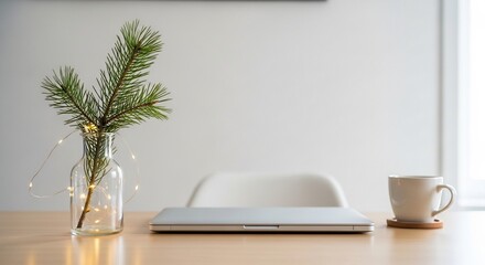 Minimalist workspace with laptop, coffee, and festive greenery for a cozy ambiance.