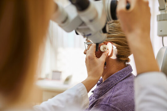 ENT physician examining ear of a senior woman