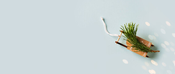 Wooden toy sledge with twig of christmas tree above