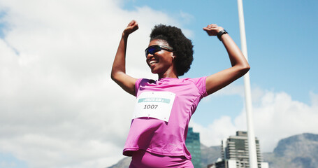 Black woman, marathon and celebration with winning at finish line with low angle, goals and...