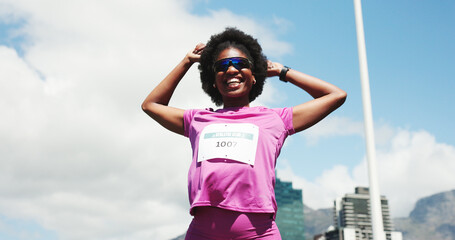 Happy, black woman or fitness with sunglasses in city for marathon, sports run or outdoor race. Below, female person or athletic runner with smile for summer challenge, sprint or competition in town © Abrahams66/peopleimages.com