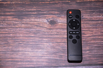 Remote control on a wooden background. Top view. Copy space. TV remote control on a table