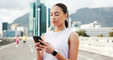 Woman, runner and phone with texting in city, bridge and break with notification, fitness and training. Person, smartphone and scroll on mobile app with search for exercise tips in town with routine
