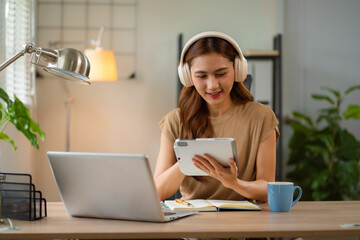 Business women hand working with tablet and laptop computer with documents on office desk in modern office.