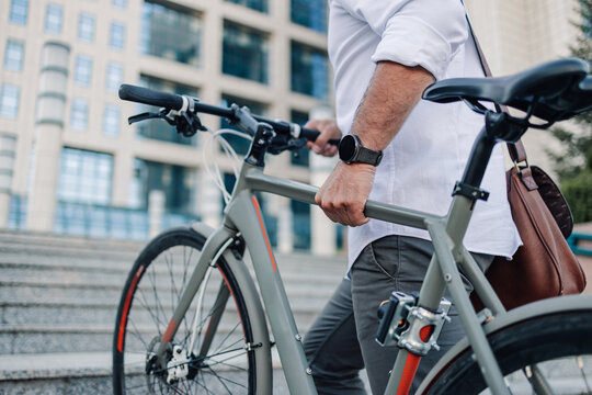 Man pushing bicycle up city stairs