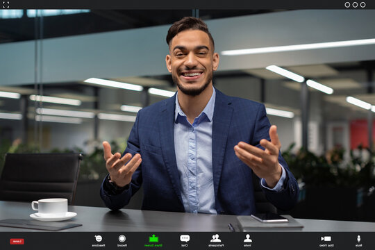 A middle eastern CEO is enjoying a video conference with clients. He looks happy, smiling, and gesturing while maintaining eye contact. The setting suggests a modern office with ample light.