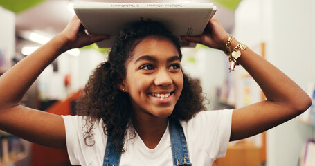 Happy girl, student and education with book in library for study, learning or academic journey. Child, kid or learner with smile, story or novel for reading, knowledge or wisdom for youth development