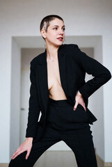 Confident young woman with alopecia posing in a stylish black suit