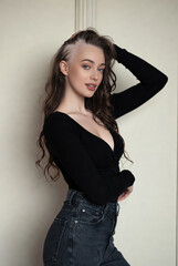 Confident young woman with Alopecia posing indoors in stylish black outfit