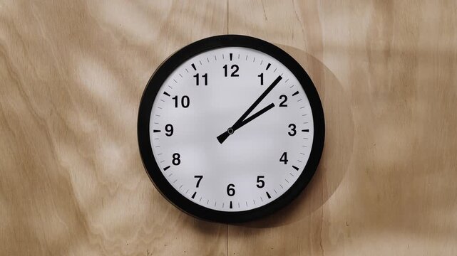 Time lapse video of classic black and white wall clock hands against  beige background. A symbol of the transience of time and life.