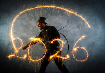 Schornsteinfeger in Arbeitskleidung schreibt mit Wunderkerzen, 2026. Symbolbild für das Neue Jahr.