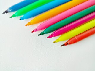 Fototapeta premium colorful uncapped markers on a white background