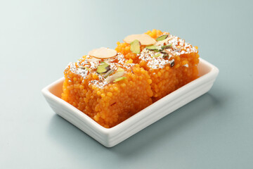 Boondi Halwa garnish with silver and roasted nuts served in ceramic plate. Popular Indian sweet