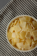 Hard Shaved Parmesan Cheese in a Bowl, top view. Flat lay, overhead, from above.