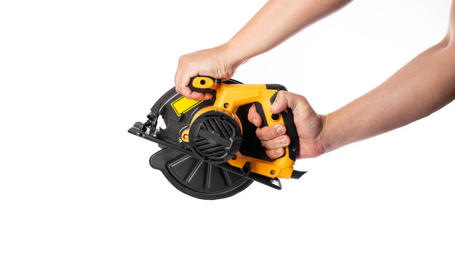 A powerful electric hand-held circular saw in a man's hands, isolated on a white background, close-up. Woodworking tool, industry