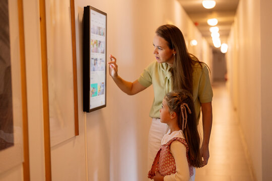 Mother daughter exploring interactive display at museum learning technology