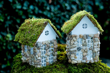 Miniature fairy houses with moss roofs in green garden