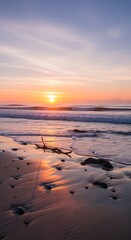 Vibrant sunset over the ocean with reflections on the wet sandy beach.